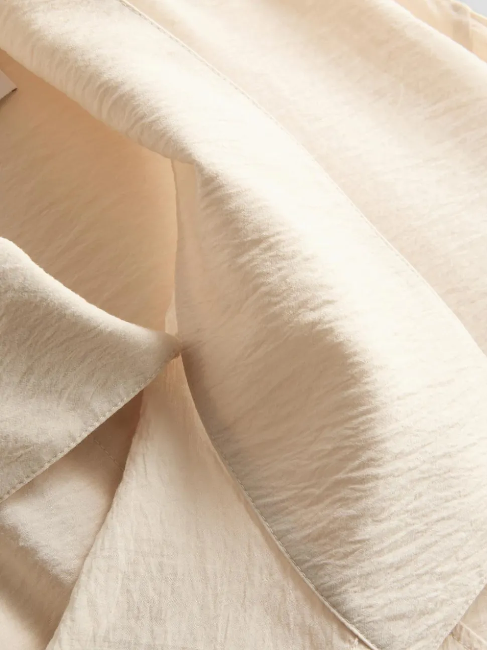 Bluse mit hohem Trichterkragen und Knöpfen
