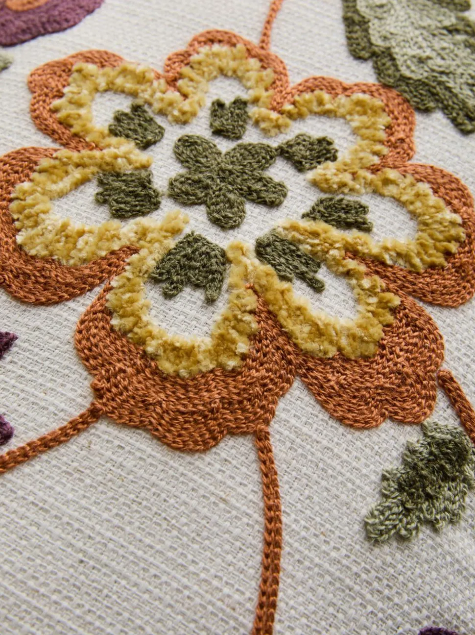 Längliches Kissen mit aufgesticktem Blumenmuster